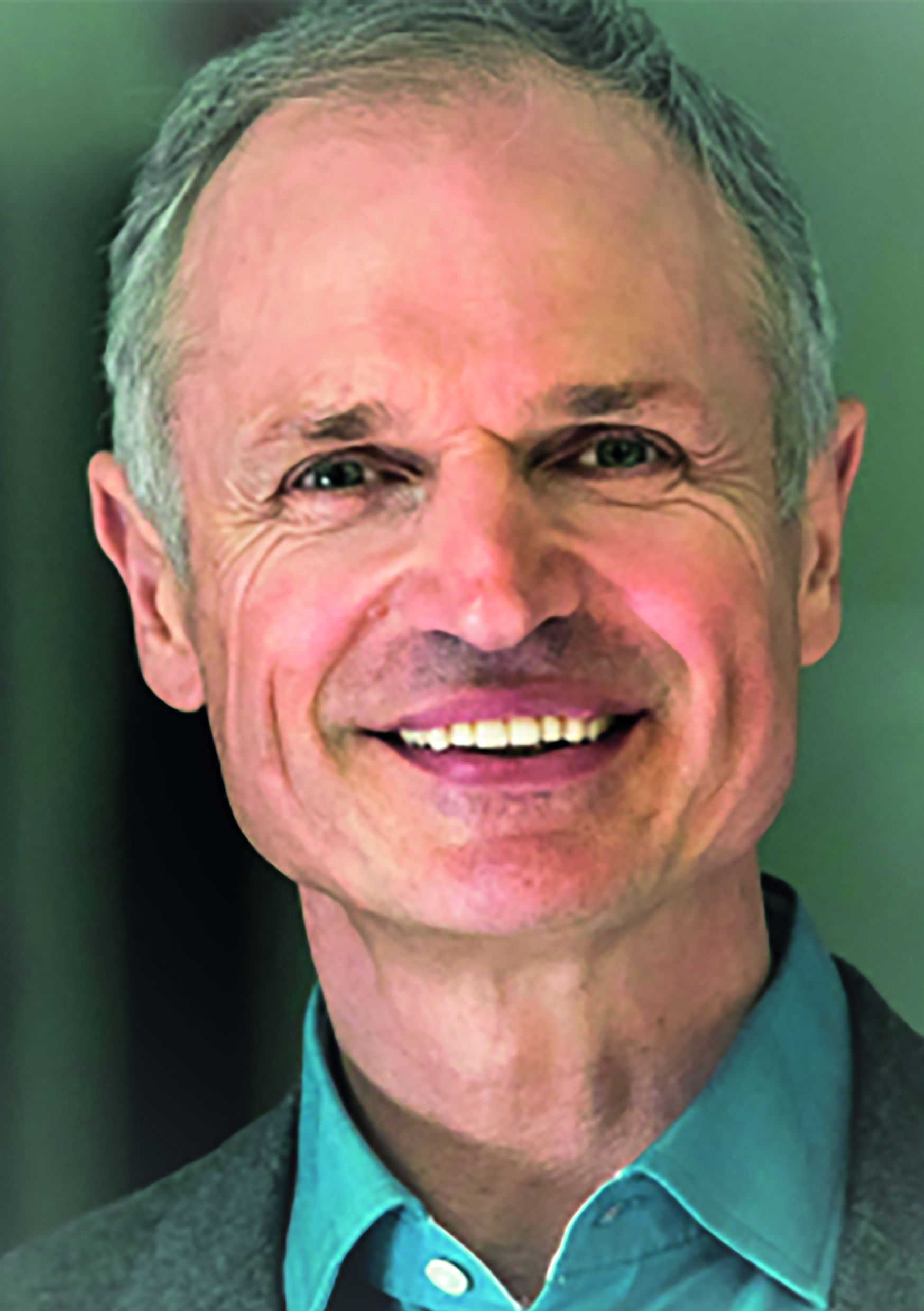 Ein lächelnder Mann in einem blauen Hemd, Nahaufnahme.